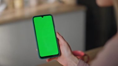Chromakey akıllı telefon mesajı okuyan kadın mutfağı kapatıyor. Sabah elinde yeşil ekran cep telefonu tutan tanınmayan bir kız. Bilinmeyen ev hanımı cep telefonundan sosyal medyayı izliyor.