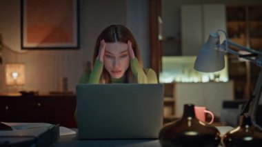Karanlık ev işyerinde dizüstü bilgisayardan gelen hayal kırıklığına uğramış serbest çalışan videosu. Stresli bir kadın internet üzerinden iş krizini tartışıyor. Yorgun iş kadını sohbet eden web kamerası tatminsiz hissediyor.