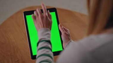 Kız elleri yeşil ekran tabletini kaydırarak sosyal medyada haber akışını izliyor. Tanınmayan bir kadın kroma anahtarına dokunuyor. Bilinmeyen serbest çalışan kadın model aygıt kullanıyor..