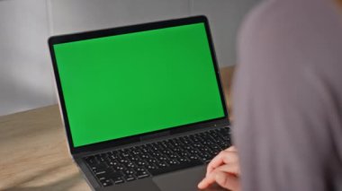 Tanımlanamayan öğrenci evde oturmuş yeşil ekran dizüstü bilgisayar çalışıyor. Kadın elleri dokunaklı bilgisayar dokunmatik ekranlı internette sörf yapıyor. Bilinmeyen serbest çalışan kroma anahtar aygıtı üzerinde çalışıyor.