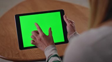 Evdeki el yakınlaştırma tabletini kapat. Yeşil ekranda sosyal medyayı izleyen tanınmayan bir kadın oturuyor. Bilinmeyen kız kroma anahtar aygıtı kullanarak çevrimiçi proje geliştiriyor.