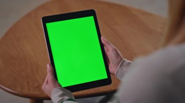Modern bir dairede oturan kadının elleri yeşil ekran tableti tutuyor. Krom tuş takımlı bilgisayara bakan tanınmayan bir kadın serbest yazar. Kimliği belirsiz bir kız internette model cihazıyla çalışıyor..