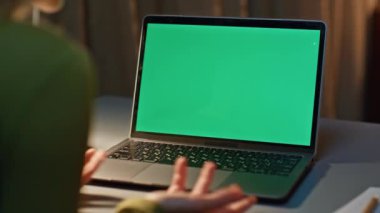 Freelancer videosu, karanlık dairede dizüstü bilgisayarı arıyor. Çevrimiçi konferansta yeşil ekranda konuşan tanınmayan iş kadını. Web sohbetine göre uzak çalışan çalışma görevini tartışıyor.