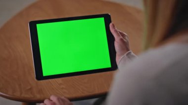 Tanınmayan bir kadın Chroma Key Tablet 'ten alışveriş yapıyor. Oturduğu daireye yakın. Yeşil ekranlı bilgisayara dokunan kız elleri online sipariş veriyor. Model aygıtı üzerinde bilinmeyen serbest çalışan tarayıcı web sitesi.