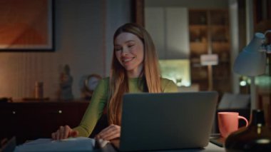 Geç saatlere kadar çalışıp dizüstü bilgisayarda proje yaratmak tatmin edici. Bilgisayarda daktilo eden mutlu bir kadın akşam evinde kendini başarılı hissediyor. Gülümseyen çekici kız ekran görüntüsü alıyor fazla mesai yapıyor..