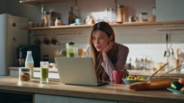 Mutfakta çalışan serbest çalışan bir kız sabah kahvesinin tadını çıkarıyor. Akıllı online öğrenci, mutfak tezgahında dizüstü bilgisayar kullanarak ders çalışıyor. Kahvaltıda iş e-postaları okuyan odaklanmış güzel bir kadın..