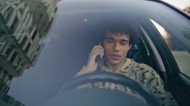 Odaklanmış sürücü, arabanın içinde cep telefonuyla konuşuyor. Latin Amerikalı adam siyah otomobille akıllı telefonu arıyor. Genç bir öğrencinin portresi modern araçta cep telefonu sohbetinin keyfini çıkarıyor.