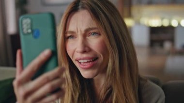 Evdeki akıllı telefon uygulamasından kadın video görüşmesi. İnternette konuşan heyecanlı kızın portresi haberlerde duygusal tepki veriyor. Mutlu tatlı bayan evde uzaktan iletişimin keyfini çıkar..