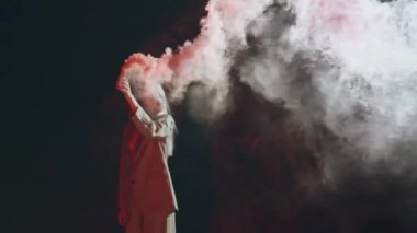 Geceleri elinde el bombası tutan güzel bir kadın. Performans güzeli kız kameraya bak renkli dumanlı bomba yapıyor. Parti mankeni açık hava festivalinde duman bulutu içinde durarak eğleniyor. Özgürlük feministi ayaklanması