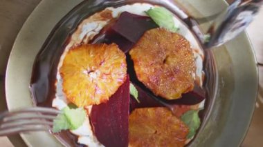 Yakından bakan eller kafeteryada çatal ve kaşıkla greyfurt pancarı aperatifi alıyor. Akdeniz mutfağında yemek yiyen tanınmayan müşteriler doğu yemeklerini dikey yiyorlar..