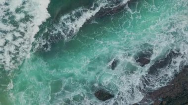 Okyanus dalgaları engebeli uçurumlara çarpıyor. Dramatik deniz dalgaları kıyı şeridini vurdu. Kayaların etrafında kabaran köpük doğanın güçlü güzelliğini gözler önüne seriyor. Çarpıcı turkuaz dalgalar savruluyor vahşi kıyılara sıçrıyor.