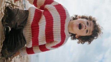 Küçük çocuk bulutlu bir günde annesiyle kumsalda konuşuyor. Sevimli çocuk, sonbahar haftasonu deniz kıyısında dikey olarak oynuyor. Şirin kıvırcık çocuk bahar tatilini okyanusta bilinmeyen bir bakıcıyla geçirir. Aile pikniği