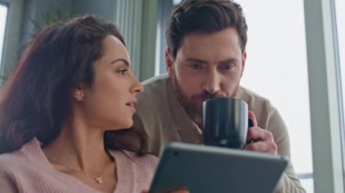 Gri apartman kapanışında konuşan tablet ekranlı bir sabah çifti. Pozitif aşıklar panoramik otelde yemek siparişi veriyor. Evli çift modern mutfakta haberleri tartışıyor.