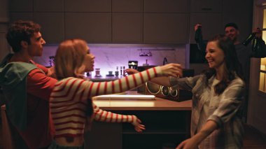 Arkadaşlar akşam evde buluşup kucaklaşıyorlar. Gülümseyen mutlu meslektaşlar geceleri apartman mutfağında toplanıyor. Neşeli arkadaşlar dost canlısı gece partisine geliyor. Takılma konsepti.