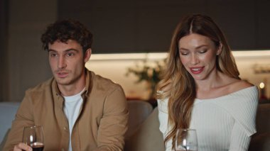 Romantik bir çift, akşam buluşmasında şarap kadehlerini yakından tutarak rahatlıyor. Genç çift, apartman kanepesinde utangaç konuşuyorlar. Gülümseyen ruh eşleri rahat koltukta oturup, şefkatli bir ilişkinin tadını çıkarıyorlar. Aşk konsepti.