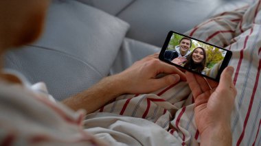 Rahat adam akıllı telefondan arkadaşlarıyla video görüşmesi yapıyor. Ekranda el sallayan neşeli çift dışarıda haberleri paylaşıyor. Elinde cep telefonu olan tanınmamış bir adam sanal buluşmanın keyfini çıkarıyor. Aile bağlantısı kavramı