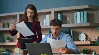 Finans şirketindeki kadın asistanla konuşan güvenilir CEO belgeleri inceliyor. Ciddi patron gülümseyen kadın sekretere evrakları veriyor. İki meslektaş şirket ofisinde anlaşma yapıyor.