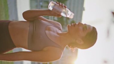 Spor salonunda su içen susamış bir kadın dikey olarak dikey çekim yapıyor. Gün batımında şişeyi elinde tutan yorgun ve formda bir bayan. Koşu egzersizlerinden sonra sakin bir sporcu dinleniyor. Koşucu eğitim molası 