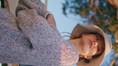 Güneşin altında dinlenen turistler dikey olarak dinleniyor. Şapkalı kaygısız gezgin kız gün batımında kameraya bakıyor. Sakin bir model. Tekneye yaslanıp gölde huzurlu bir hafta sonunun tadını çıkarıyor.