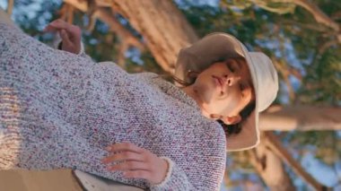 Yazlık kadın dışarıda dinleniyor, dikey olarak yakın plan. Gün batımında parkta tek başına rahatlamış bir model kamera. Sakin sakin gezgin hafta sonu dinlenirken tekneye yaslanıyor. Tatil gevşemesi