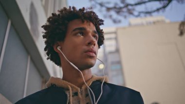 Kulaklıkla şarkı dinleyen Mixedrace denen adam şehir merkezinde geziniyor. Kıvırcık, ciddi bir genç, kulaklıkla müzik dinlemekten hoşlanıyor. Şehir caddesinde yalnız yürüyor. Yakışıklı genç hippi haftasonunu dışarıda geçiriyor..