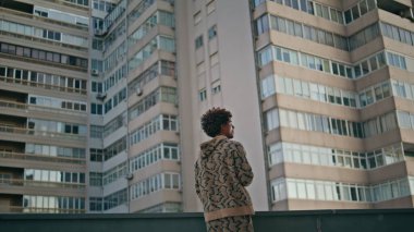 Kıvırcık adam şehir manzarası inşa etmeye çalışıyor. Sakin bir şehirde rahat Latin Amerikalı bir adam sıradan bir kazakla sigara içiyor. Genç milenyum, dışarıda tek başına dinleniyor. Kötü alışkanlıklar konsepti.