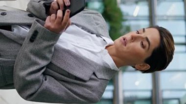 Ofisteki kızgın iş kadını cep telefonundan mesaj atmış. Gergin yönetici, görüntüyü dikey bırakarak cevap gönderdi. Başarılı kadın takım elbiseli şirket yöneticisi şehir merkezindeki e-postaları cevaplıyor.. 