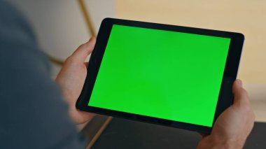 Yönetici şirket ofisinde yeşil ekran tableti arıyor. Tanınmayan iş adamı kroma tuşlu bilgisayarı yakınlaştırıyor. Kabinede çevrimiçi konferans için model monitör kullanmakla meşgul. 