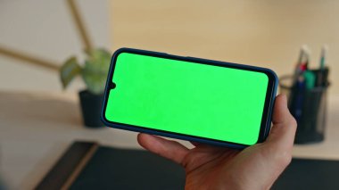 Şirketin ofisinde elinde yeşil ekran akıllı telefon tutan adam. Tanımlanamayan iş adamı içeride krom anahtarlı cep telefonu arıyor. Kabinede çevrimiçi konferans için model hücre kullanmakla meşgul bir yönetici 