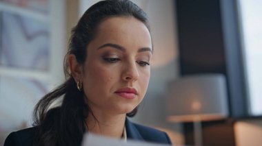 Yakın plan, masa başında evrak okuyan iş kadını odaklı. Düşünceli yürütme planlama gelecekteki ortaklık ofiste düşünme işi. Esmer kadın yönetici şirket projesini başlatma sözleşmesini onayladı