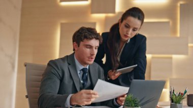 Ofis evraklarını inceleyen endişeli yöneticiler. Ciddi iş arkadaşları finansal veri çalışma bilgisayarını tartışıyorlar. Bilgi açıklayan profesyonel analist danışmanı. Takım çalışması işbirliği 