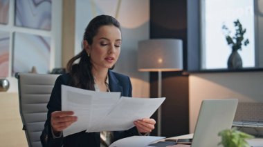 Ofisteki kadın çalışma odasının yakın çekimlerinde çalışıyor. Buro 'da denetleme yapan odaklı yönetici çalışma belgeleri. Düşünceli, mutlu bir çalışan masasında oturmuş, şirket raporlarını inceliyor. Takım elbiseli meşgul yönetici. 