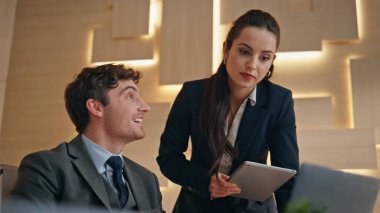 İş ortakları, geniş kabine kapanışında birlikte çalışarak anlaşma kazandılar. Mutlu iş arkadaşları dizüstü bilgisayarda beş kişi çalıştırıyor. Neşeli, gülen çift ışık ofisinin başarısını kutluyor