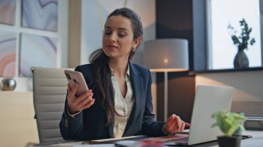 Kazanan kadın akıllı telefon gibi görünüyor. Ofiste mutluluğu yakından hissediyor. Dizüstü bilgisayar işyerindeki başarıyı kutlayan mutlu iş kadını. Heyecanlı kız profesyonel sevinç dolu zafer işi başarısı 