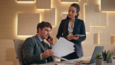 Heyecanlı ofis çalışanları mutlu hissederek harika bir iş çıkarıyorlar. Erkek, gülümseyen kadın meslektaşları arayıp kârlı bir anlaşma yapıyorlar. İki iş ortağı şirket başarısını kutlamaktan memnun. 