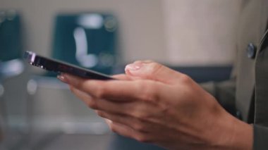 İş kadını elleri, çağdaş ofis kapanışında akıllı telefonu kaydırıyor. Ofiste cep telefonuyla dokunmatik ekranda yazan tanınmayan bir iş kadını. Sosyal medyayı cep telefonundan izleyen şık bir kız..