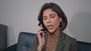 İş kıyafetleri içinde cep telefonu pazarlığı yapan odaklanmış bir kadın ofis ortamını kapatıyor. Profesyonel müdürün portresi iş telefonuyla konuşuluyor. İş yerinde akıllı telefondan bahseden gülümseyen bayan..