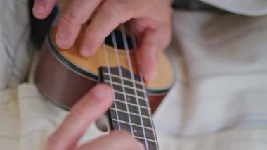 Gitarist elleri, dikey olarak sokakta gitar çalarak tellere dokunuyor. Şehir parkında gitar çalan isimsiz bir müzisyen. Bilinmeyen bronzlaşmış bir adam enstrümanla müzik dinlemekten hoşlanıyor. 