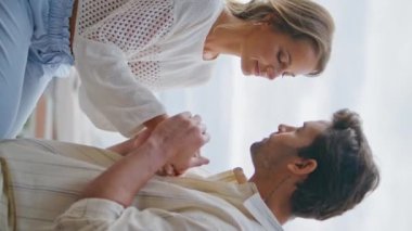 Şehirli bir çiftin öpüşme sahnesi terası tarihi dikey yakın çekim. Akdeniz 'de el ele tutuşup birbirini okşayan şefkatli bir kadın. Romantik aşıklar deniz manzarası balkonunda sevinç bağı kuruyorlar.