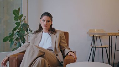 Başarılı bir kadın restoranı soğutuyor ve kamerayı kendine güvenle kapatıyor. Lüks lobide rahat koltukta oturan zarif zengin iş kadını. Çağdaş kahve evinde poz veren güzel bir esmer.