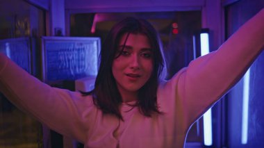 Renkli parlak ışıklarla çekilmiş neon renkli bir fotoğraf makinesi. Esmer, güzel bir kız. Telefon kulübesinde poz veriyor. Gece kulübü partisinde yalnız başına çekici ve güzel bir kulüp kadını. Gece hayatı konsepti