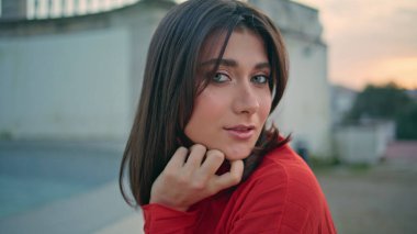 Esmer kadın şehir parkındaki portrede fıskiye gibi poz veriyor. Yaz akşamları su kenarında dinlenen sevimli, güler yüzlü bir kadın. Şehir meydanında tek başına sakin, muhteşem bir kamera. Güzellik kadınlığı konsepti 