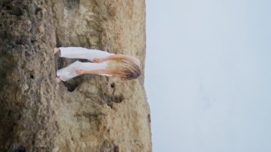 Dans sanatçısı yaz günü dikey görüntüsünde vücudunu duygusal bir şekilde hareket ettiriyor. Romantik genç kız doğada modern doğaçlama dans ediyor. Çağdaş koreografiyi icra eden tasasız kadın dansçı.