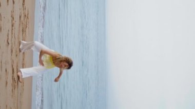 Boş deniz kıyısında dans eden kareograf kadından esinlendim. Modern stilde hareket eden esnek dansçı. Tasasız kız çağdaş koreografiyi icra ediyor.