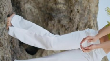 Yazın taşların üstünde dans eden şehvetli kız dikey çekim yapıyor. Hayalperest kadın dansçı doğada modern dans pratiği yapıyor. Kıvırcık kadın sanatçı baştan çıkarıcı bir şekilde hareket ediyor. Modern koreografi