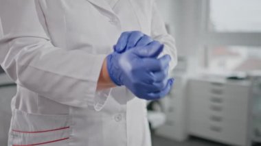 Hasta muayenesi için eldiven takan doktor elleri. Bilinmeyen bir doktor, tıbbi hazırlıkta güvenlik ve hijyene odaklanmış durumda. Sağlık kontrolü için koruyucu ekipmanla sağlık ekibi hazırlanıyor.