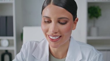 Pozitif doktor klinikte tedavi öneriyor. Poliklinikte sağlık danışmanlığında gülümseyen bir portre. Gülümseyen tıp doktoru hastanede bilinmeyen bir hastayla konuşuyor.