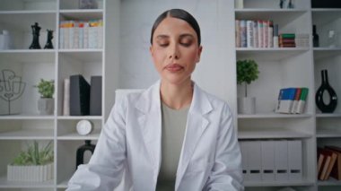 İnternetteki doktor teşhisi bilgisayardaki video görüntüleriyle açıklıyor. Kadın doktor klinik pov videosunda uzaktan danışmanlık yapıyor. Odaklanmış sağlık hizmeti sağlayıcısı tedavi tavsiyesi.