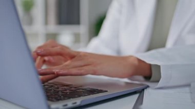 Sıhhiyeciler ofis boşluğunda dizüstü bilgisayarı daktilo ediyorlar. Meçhul kadın hekim modern klinikteki idari görevlere odaklanmış. Bilgisayarda tıbbi bilgilere giriş yapan kadın sağlık uzmanı