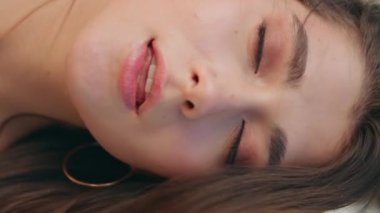 Portre romantik model gülümseyen kamera bulanık doğa dikey. Mutlu kadın yüzü yaz rüzgârının tadını çıkarırken objektife yakından bakıyor. Kırsal bölgede poz veren hassas bir kadın. Rahat kız saçı